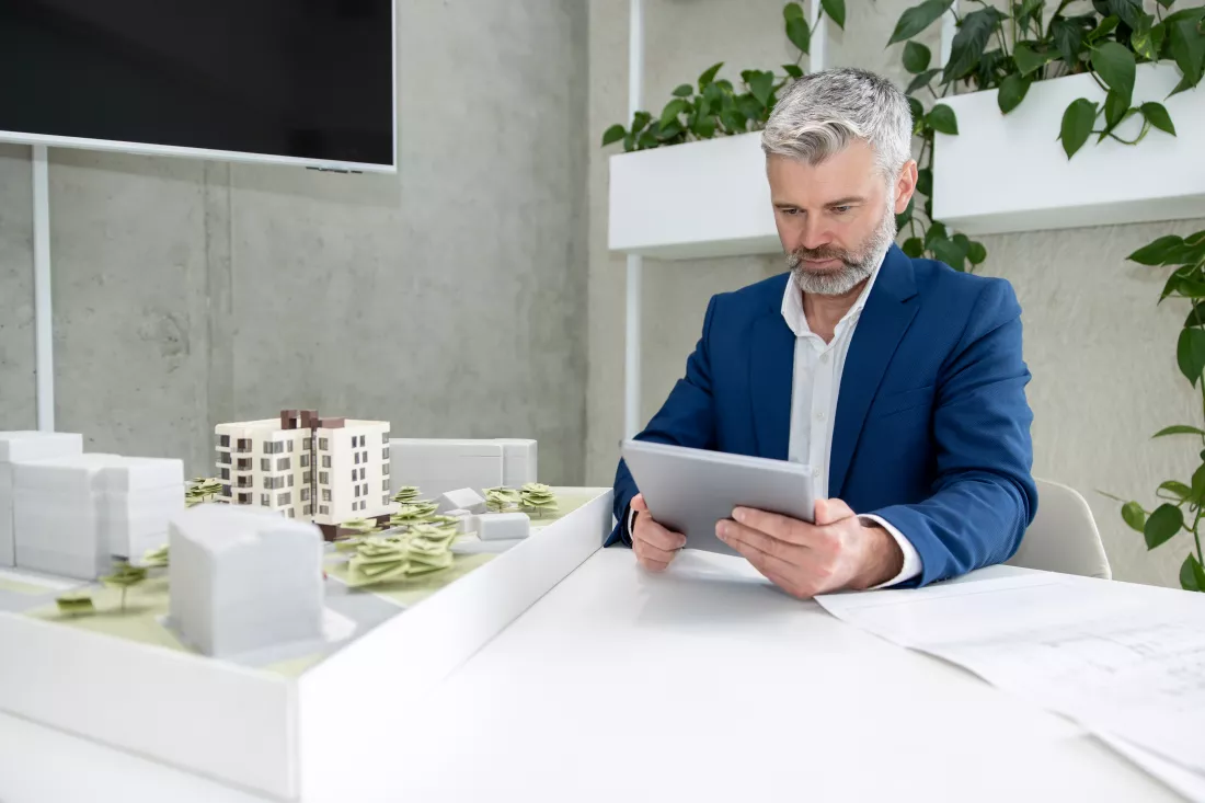 architects-engineer-working-with-blueprint-house-model-office-2